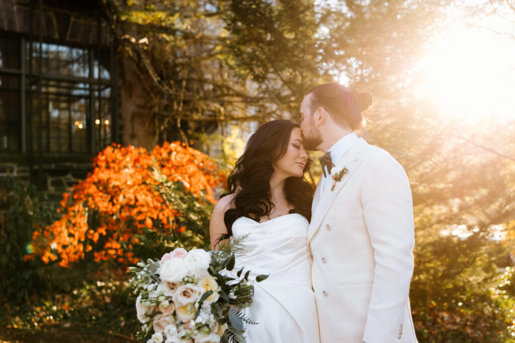 couple kiss in the fall at My Beloved Homewood.