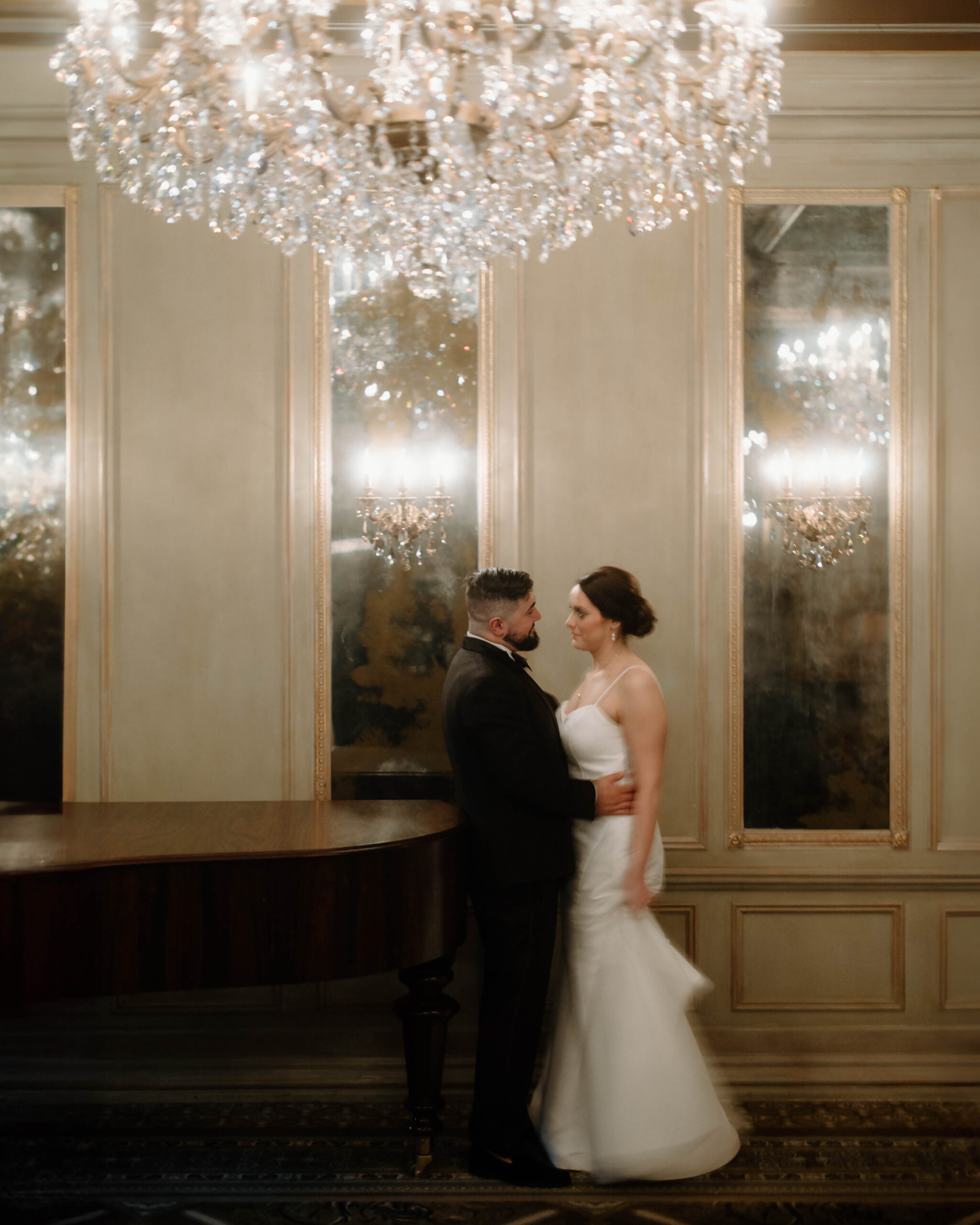 Couple embraces after their wedding at a grand piano at the Grand Bohemian Asheville