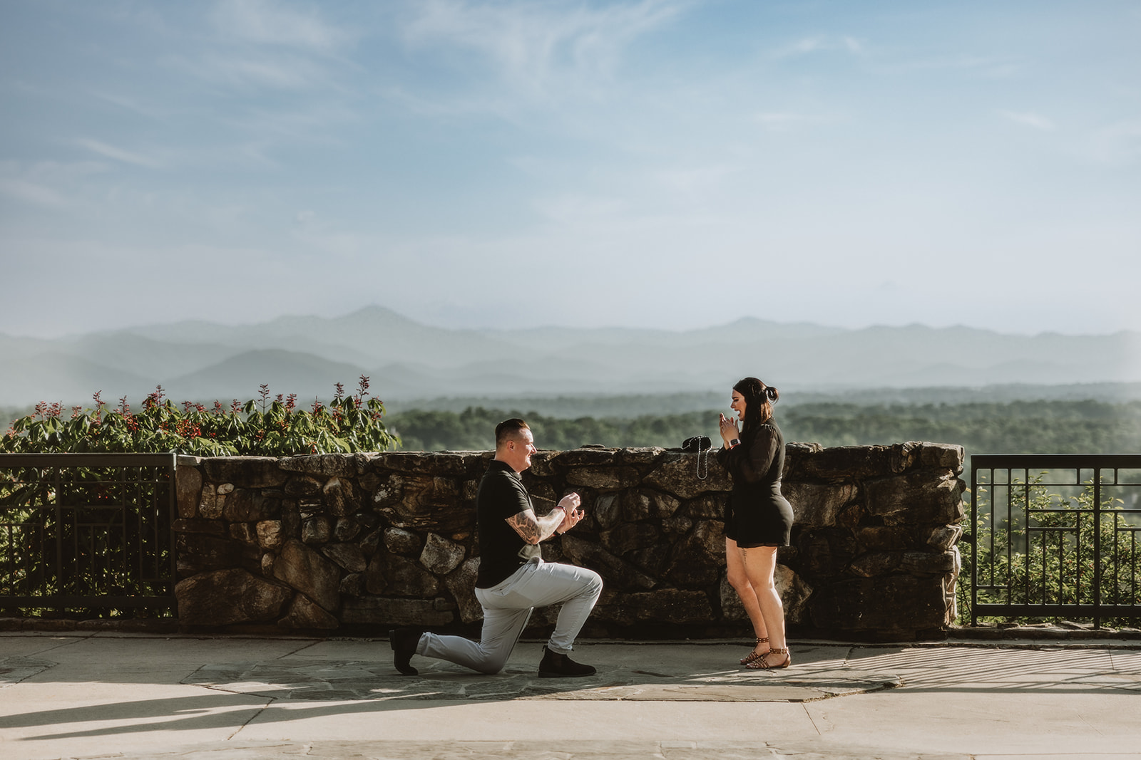 Man proposes to his fiance at The omni Grove Park in with a view of mountains in the background. 
