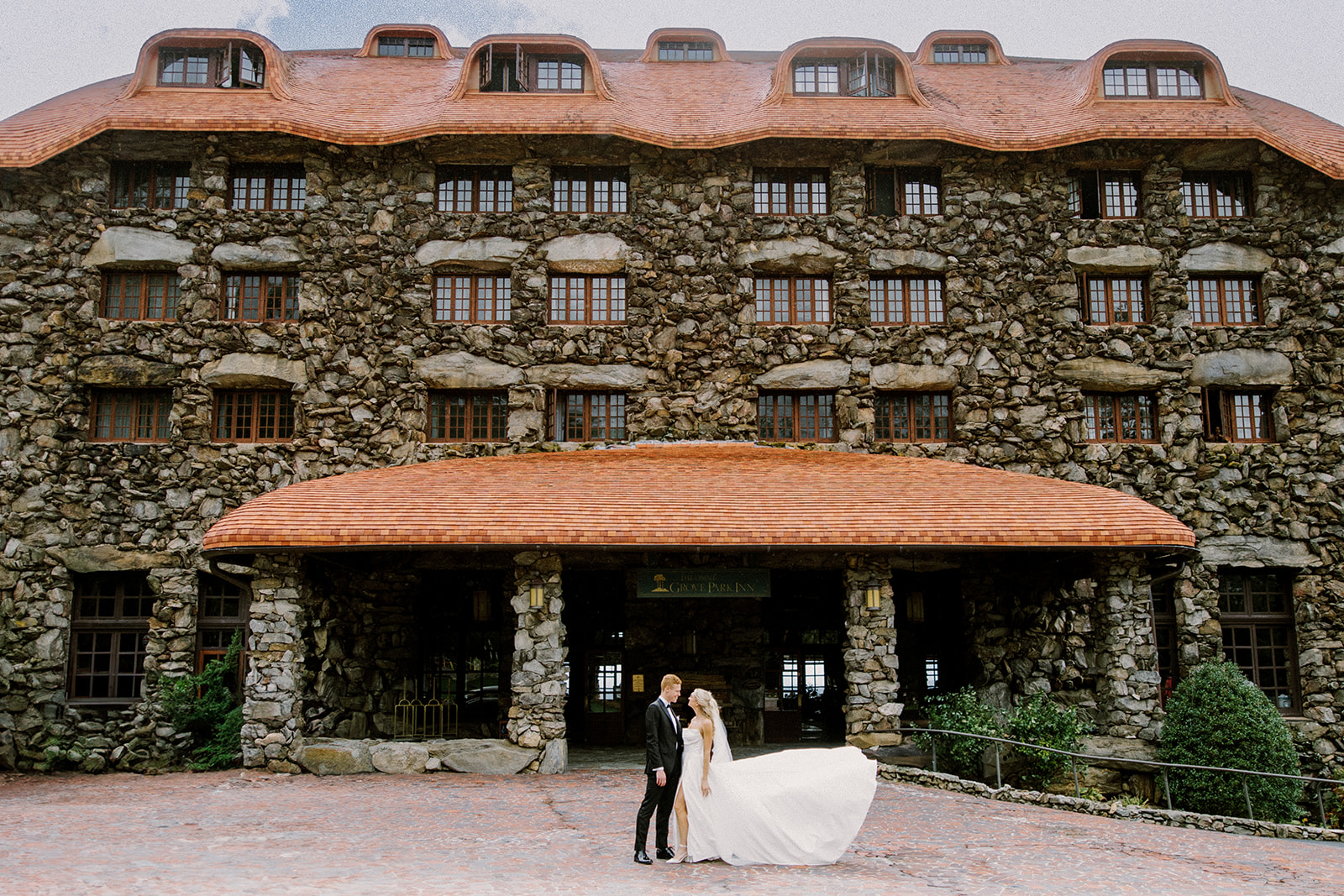 Bride and Groom look at each other out front of The Omni Grove Park Inn
