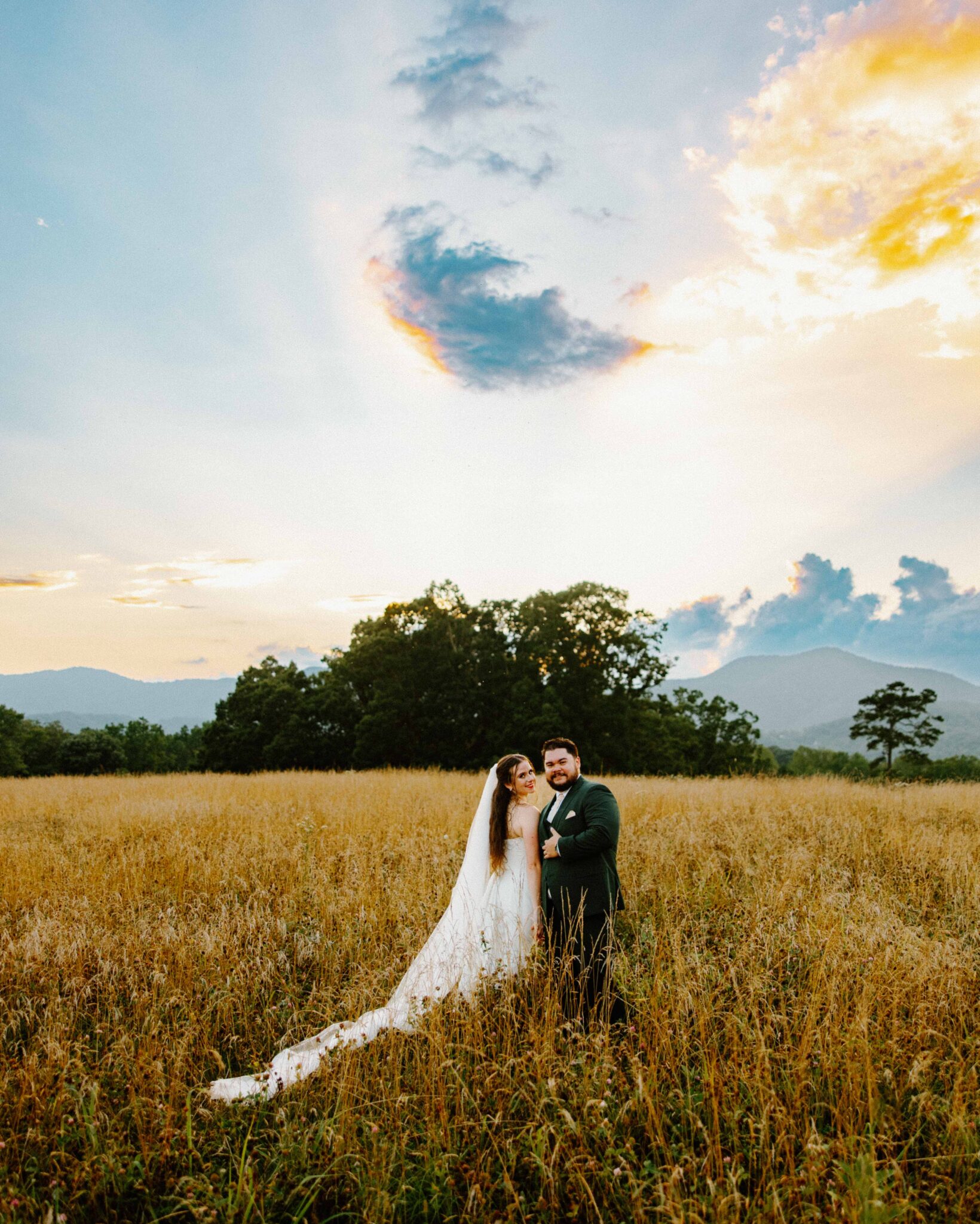 Bride and groom walking the pasture at The Farm, A Gathering Place in Asheville