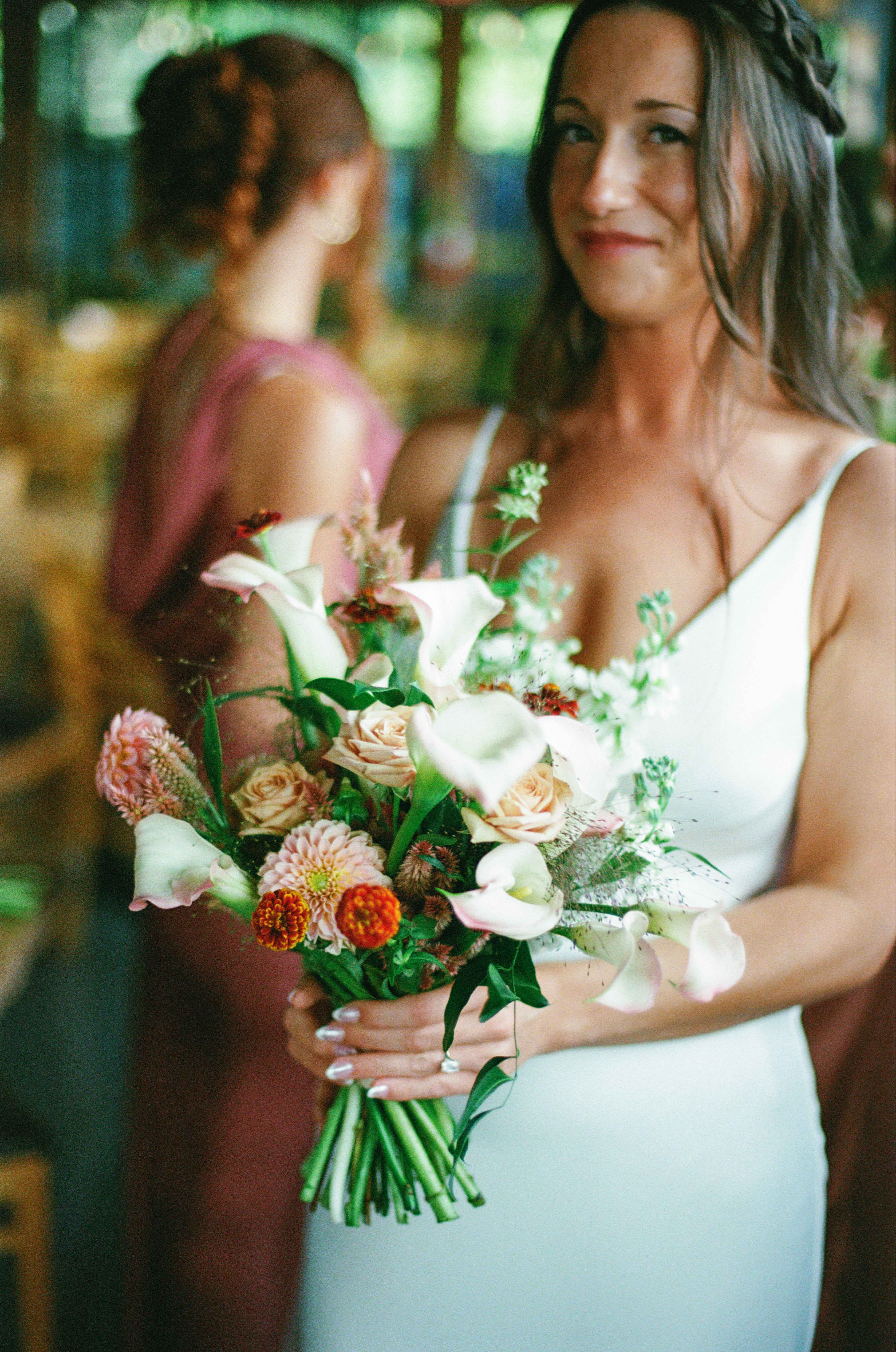 Candid film photograph of a bride holding a colorful wedding bouquet