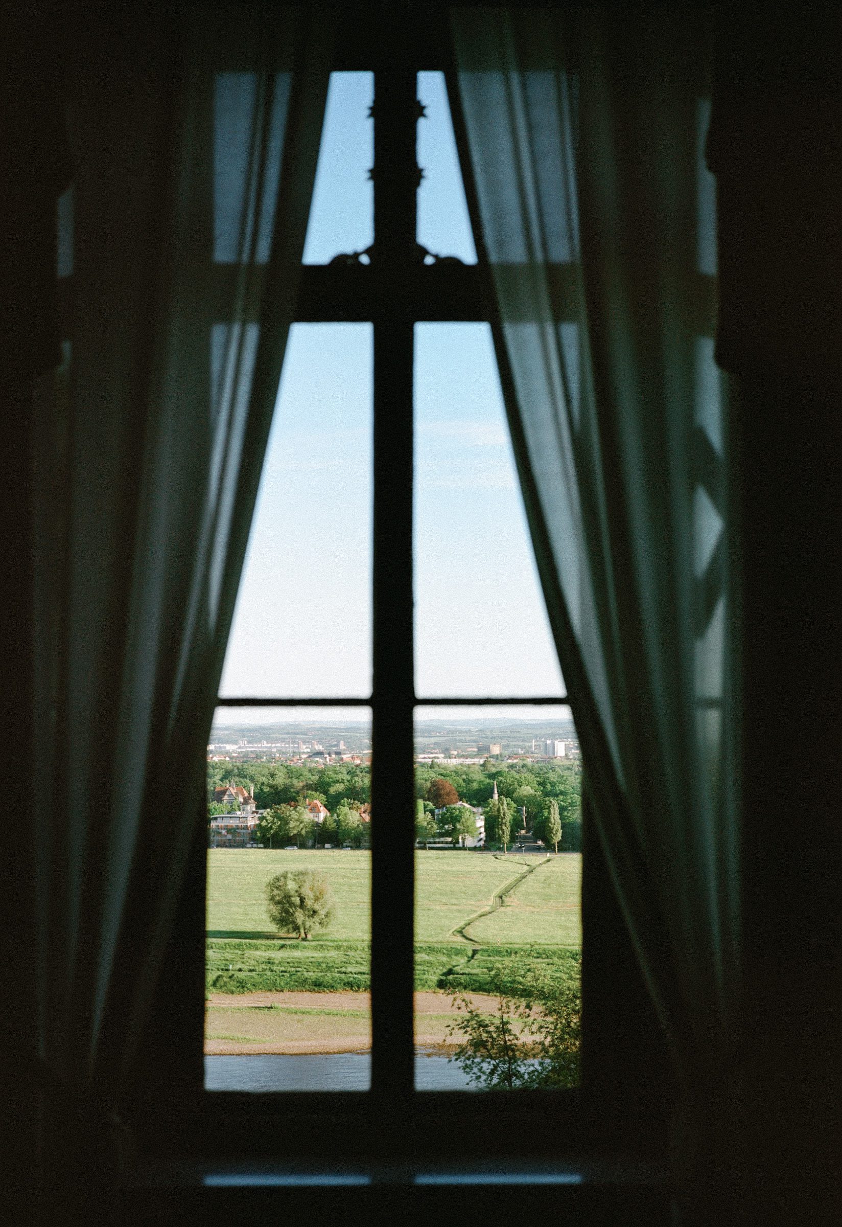 View of the Western North Carolina landscape through dark curtains and a tall window