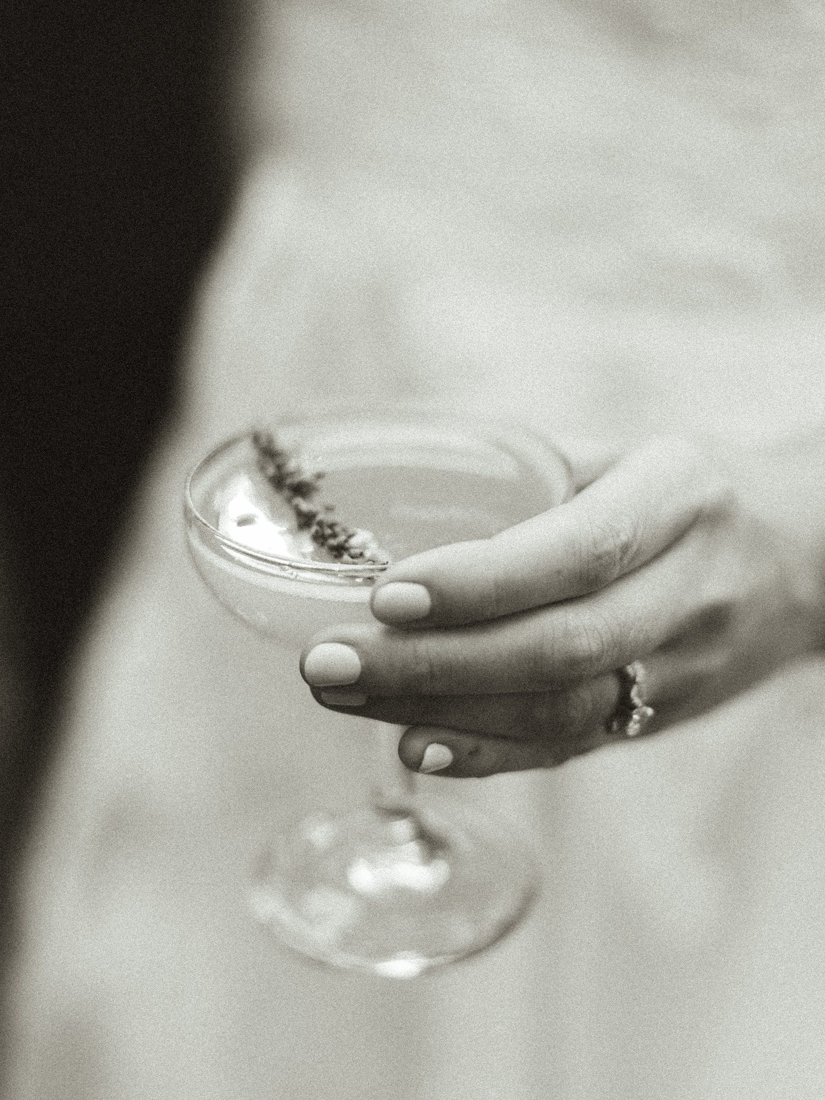 Black-and-white detail of the bride holding a drink
