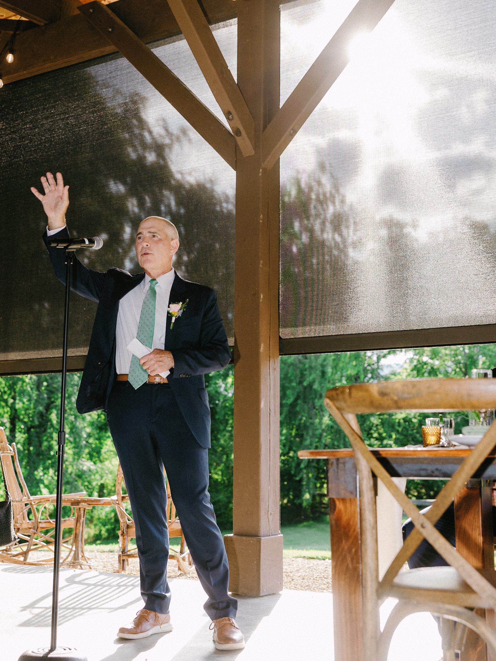 Wedding guest giving a toast beneath the pavilion