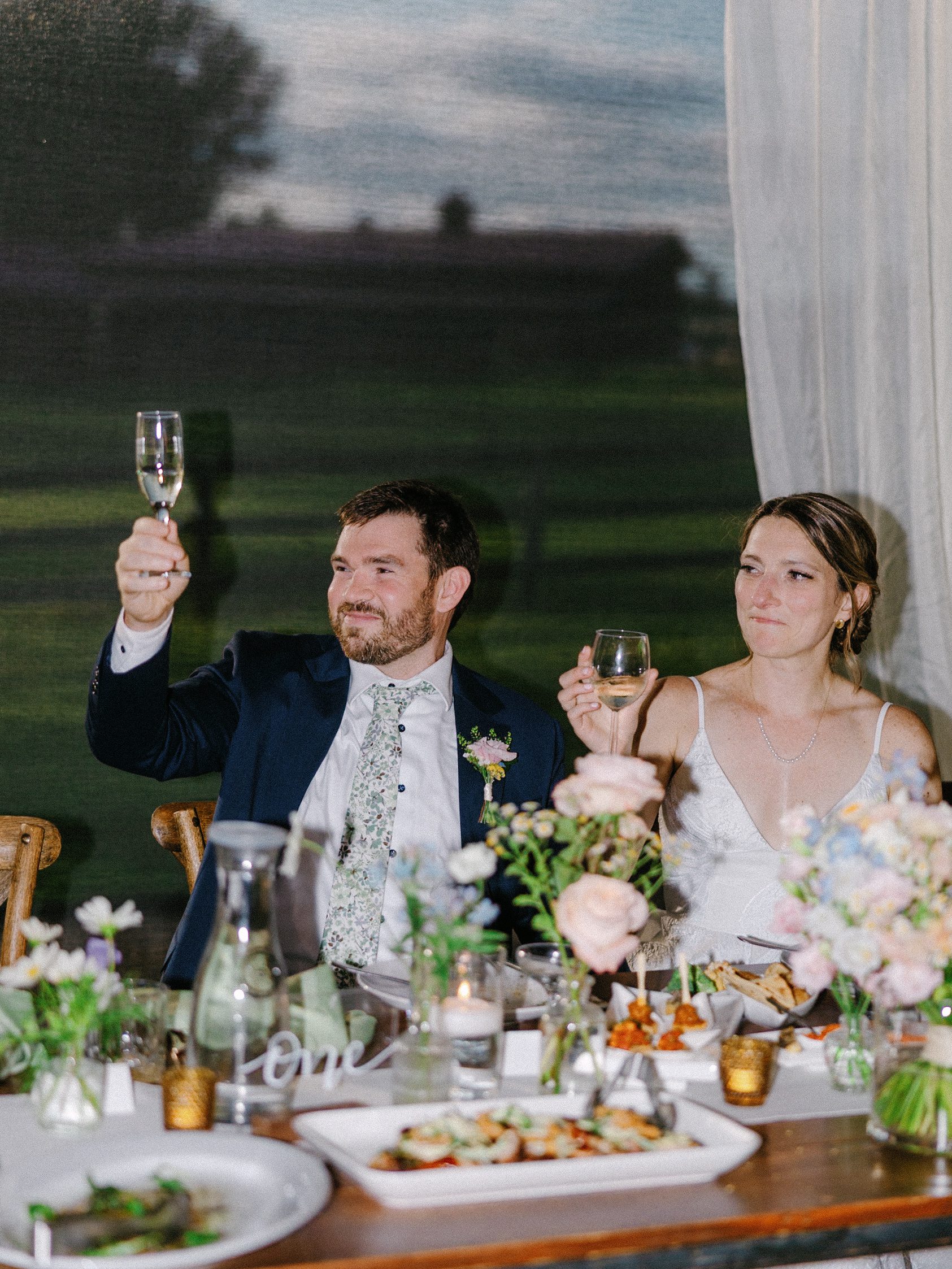Newlyweds raising their glasses during reception toasts