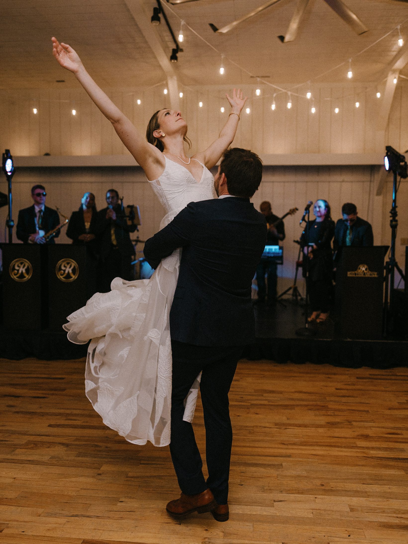 Groom lifting the bride in front of the live band
