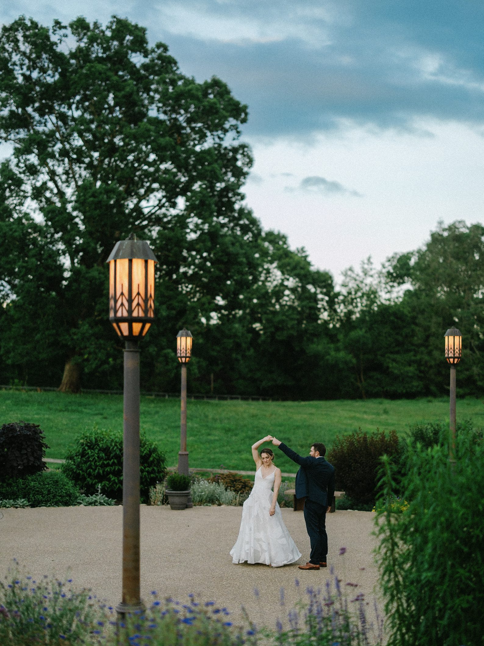 Couple twirling beneath outdoor lanterns
