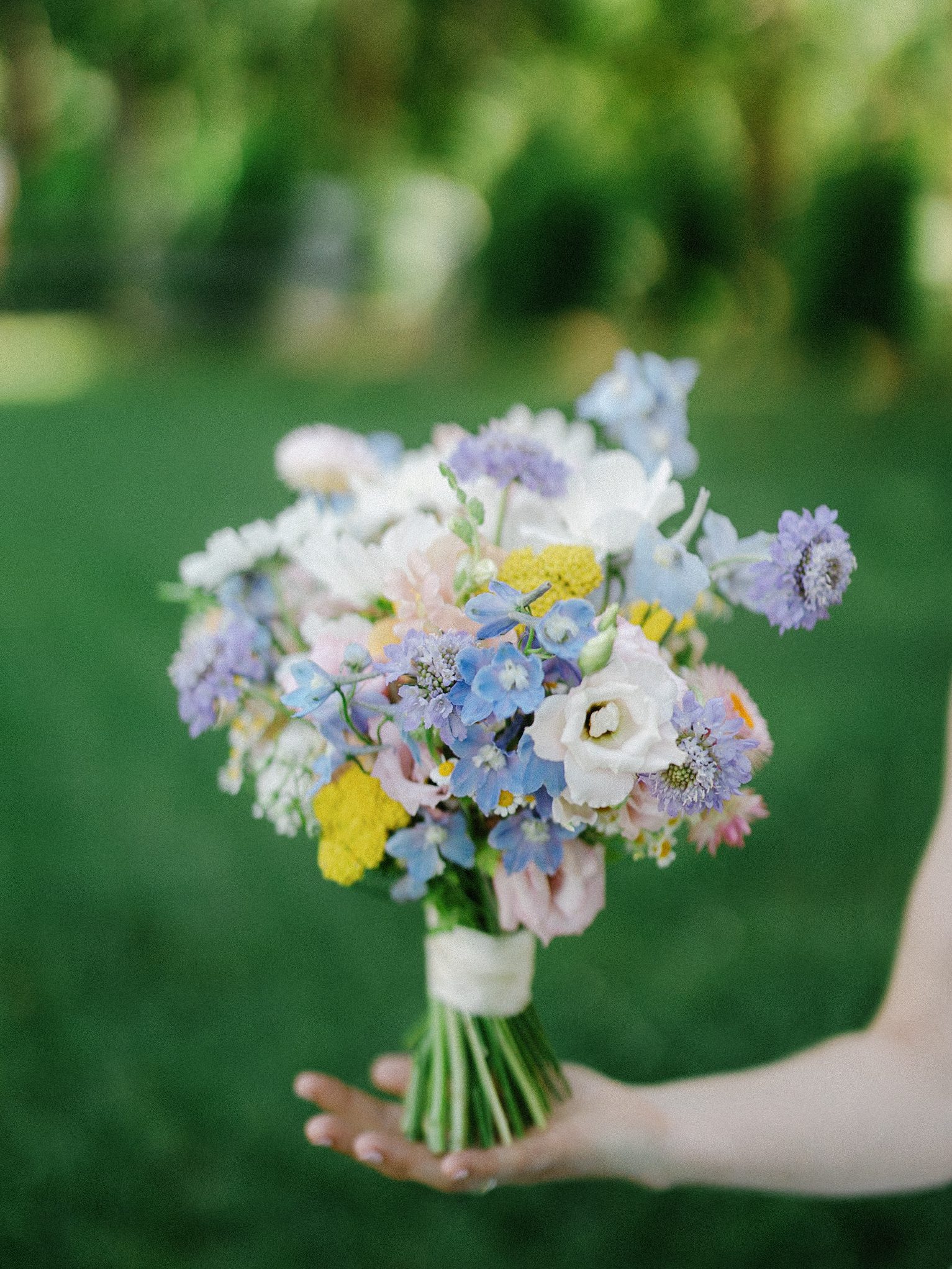 Pastel blue, lavender, pink, and yellow bridal bouquet
