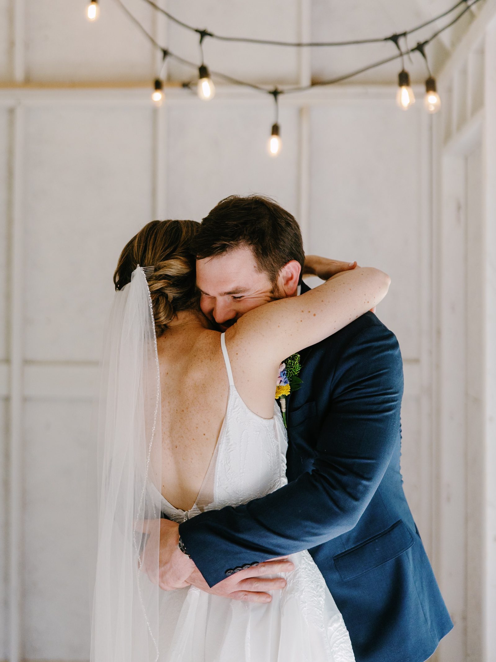 Couple embracing beneath string lights at The Farm