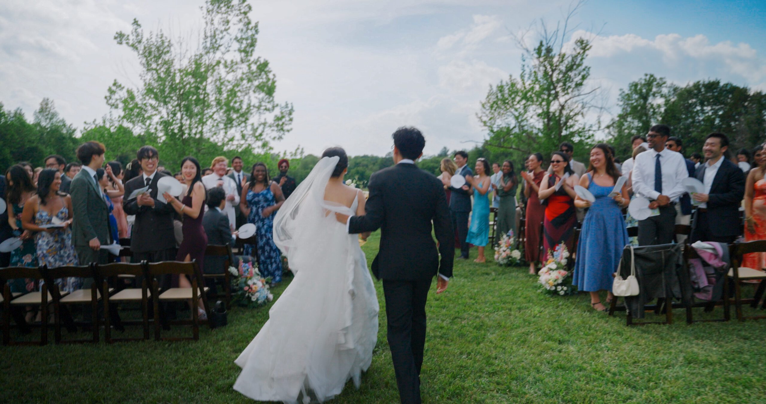 Wedding guests celebrate as Christie and Hao leave their outdoor ceremony.
