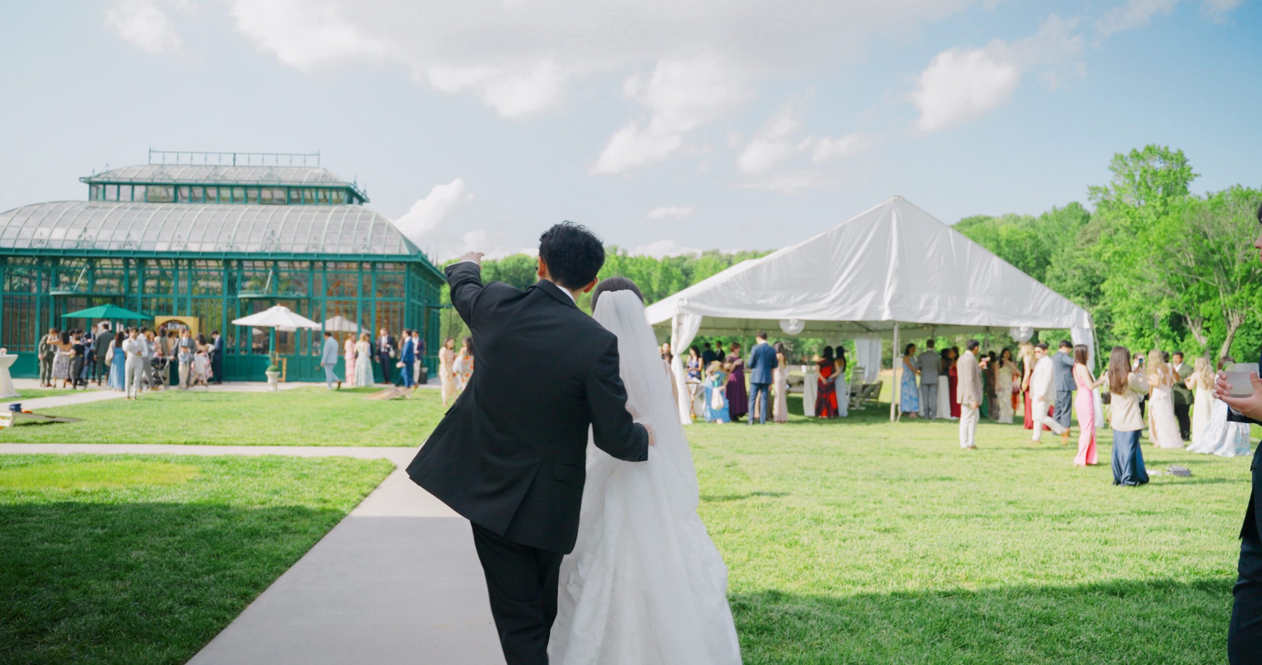 Christie and Hao walk together toward the glass Solarium after their ceremony.
