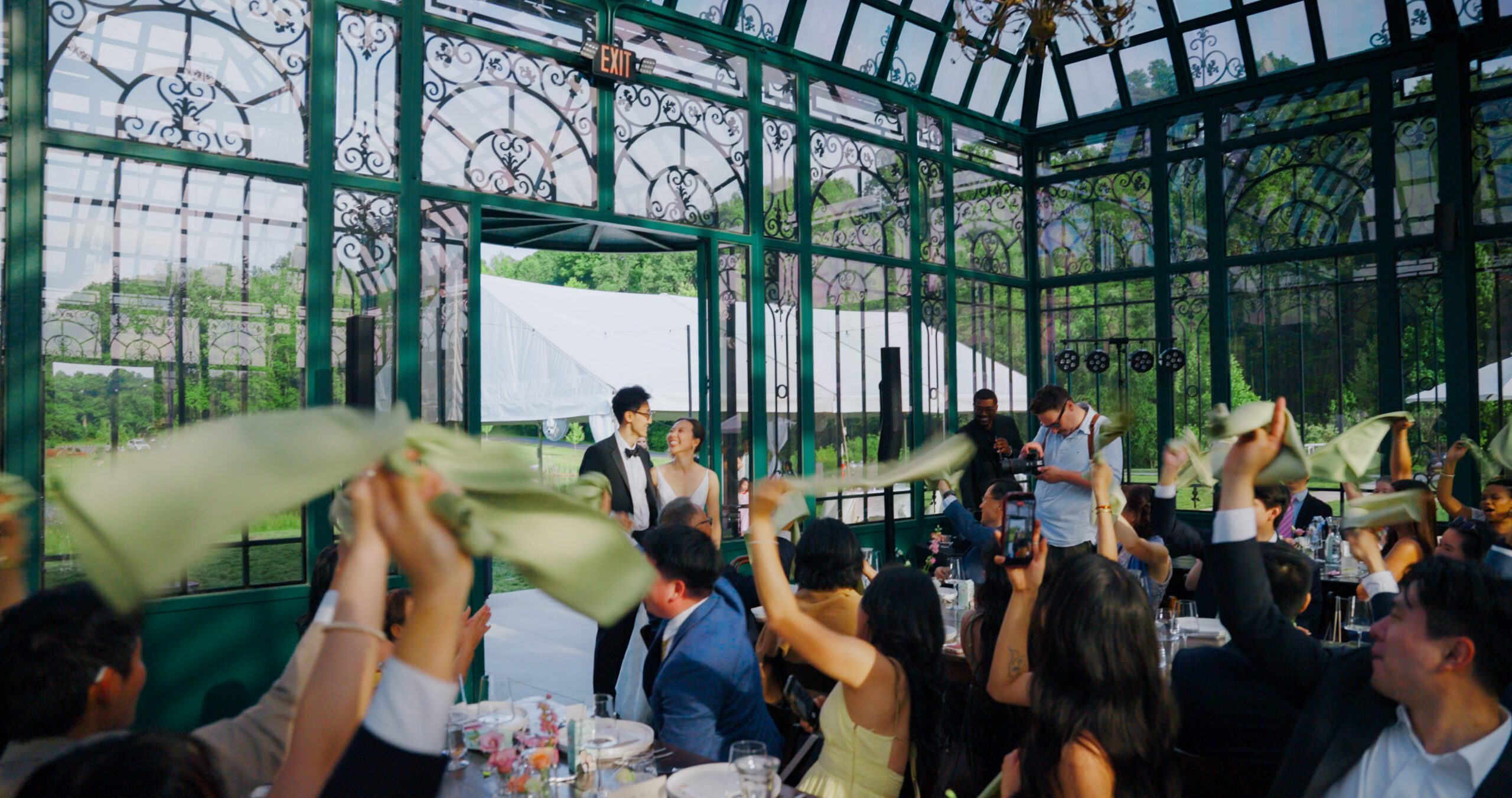 Guests raise their napkins to welcome Christie and Hao into the Solarium reception.