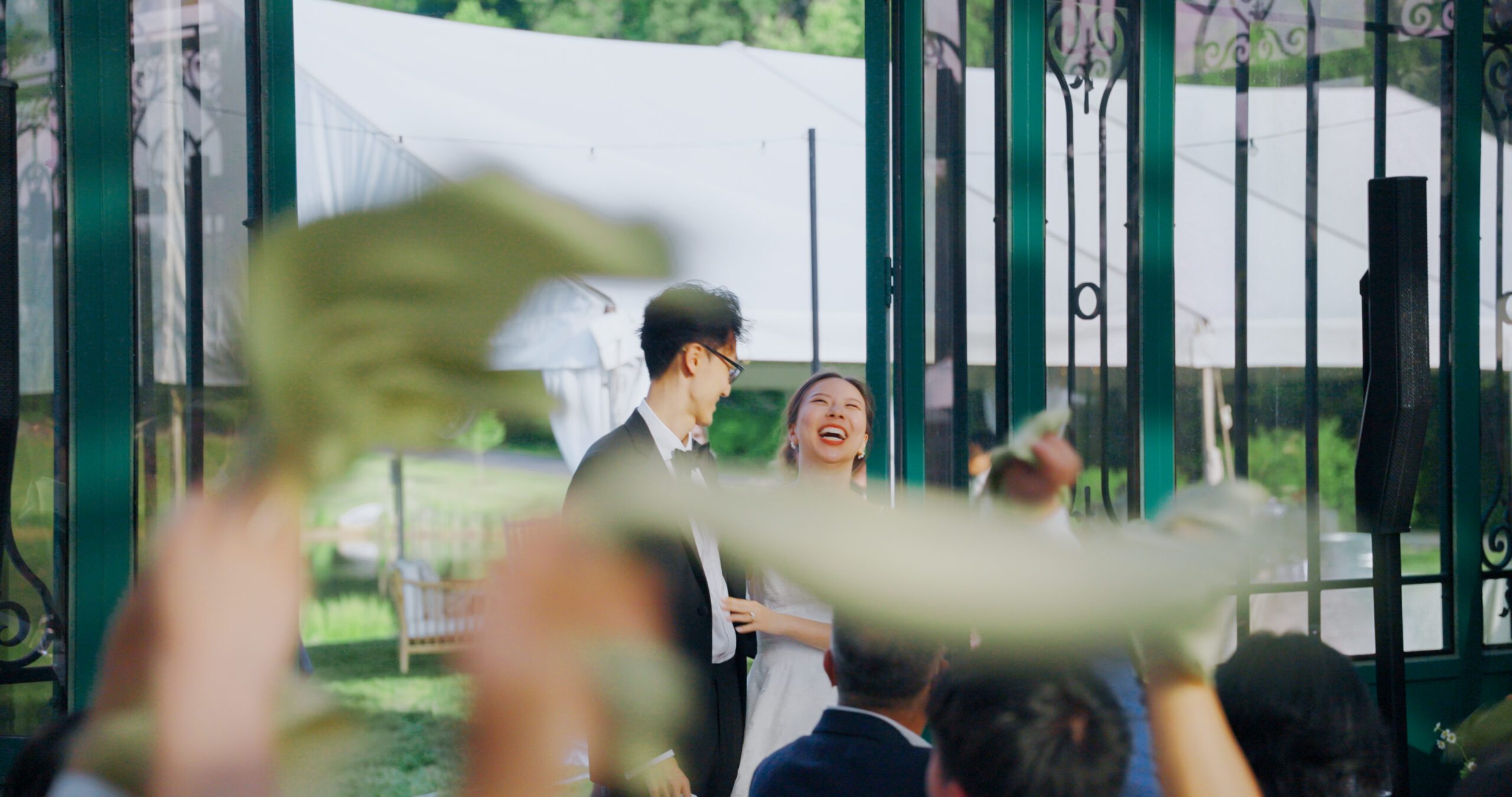 Hao smiles during the reception entrance, framed by the Solarium’s glass doors.