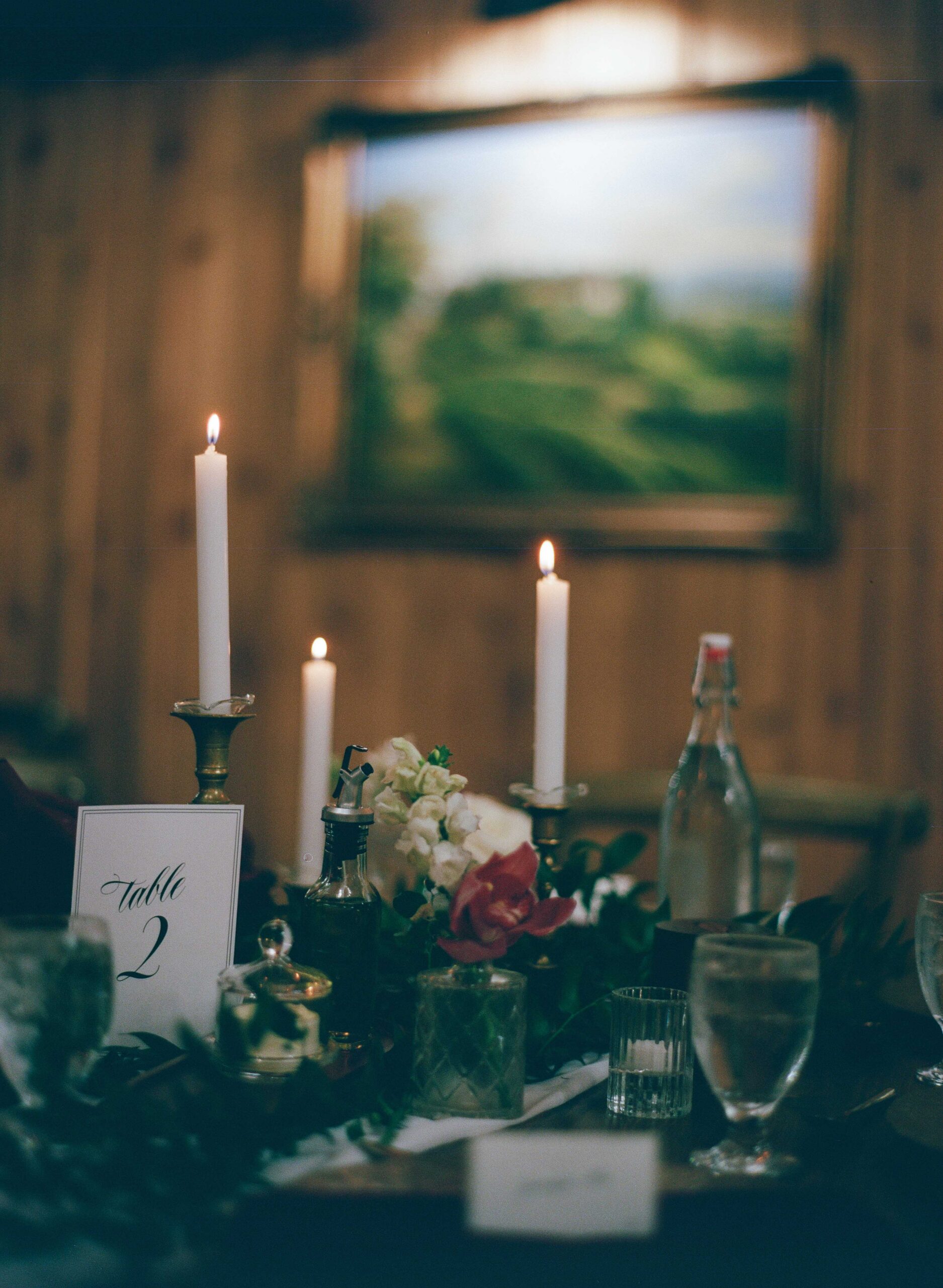 Candlelit reception table with flowers, glassware, and a table number at Twickenham House and Hall