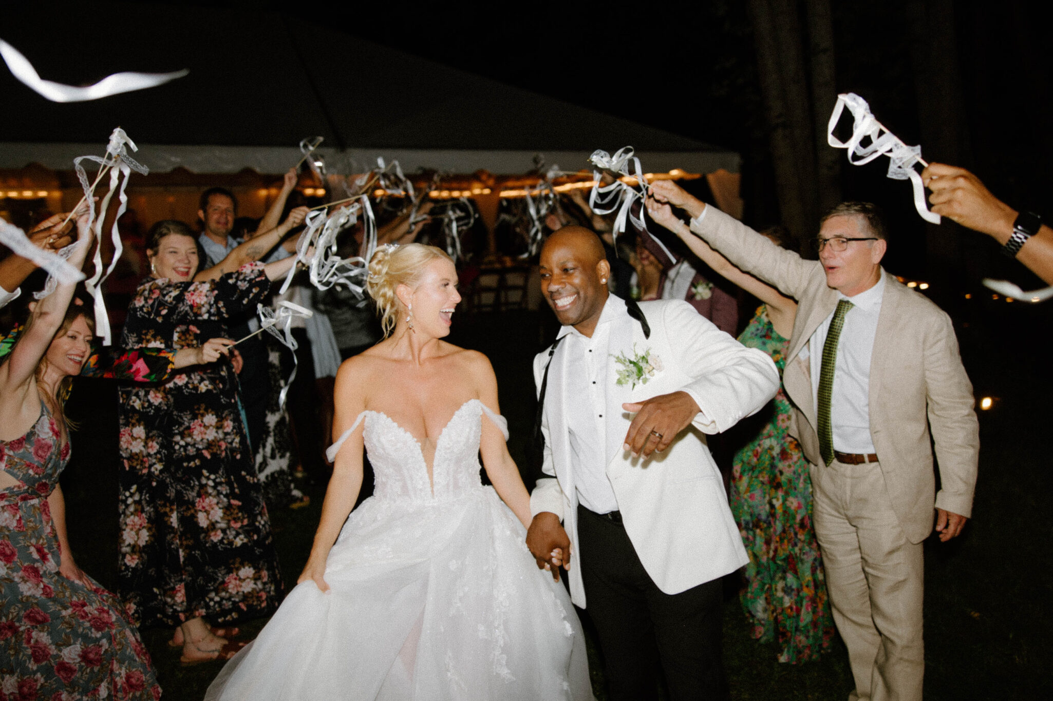 Bride and Groom exit their wedding surrounded by friends and family