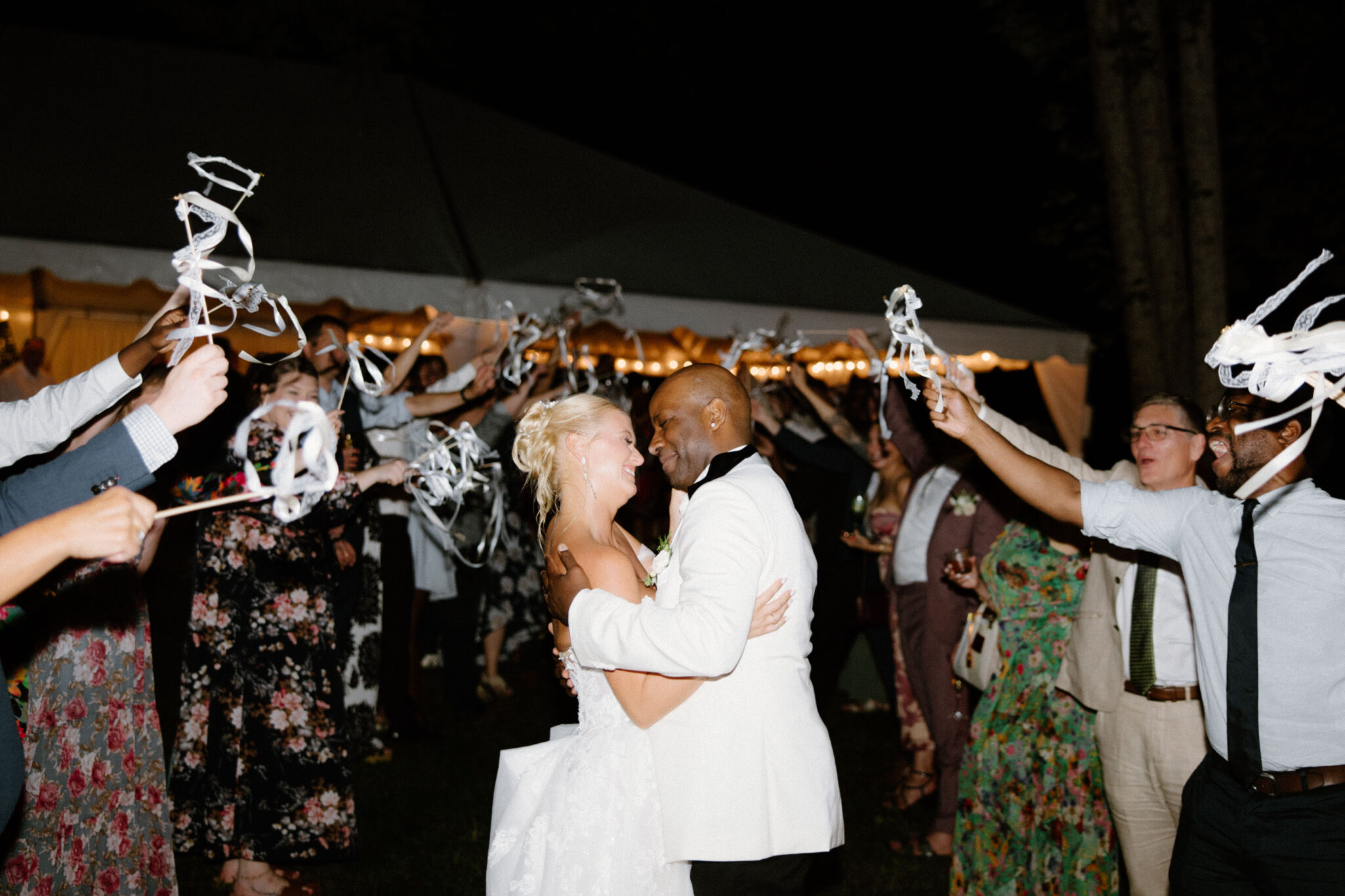 Bride and Groom exit their wedding surrounded by friends and family