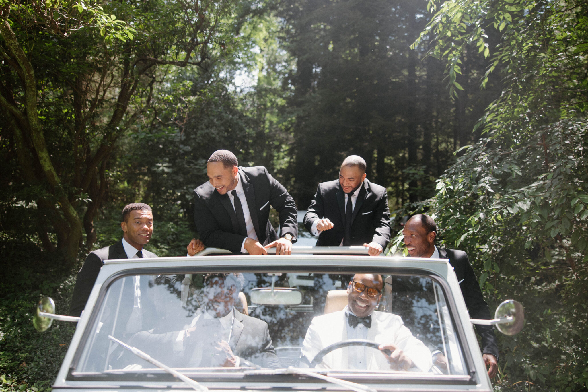 Groom and Groomsmen hanging out before wedding ceremony classic car