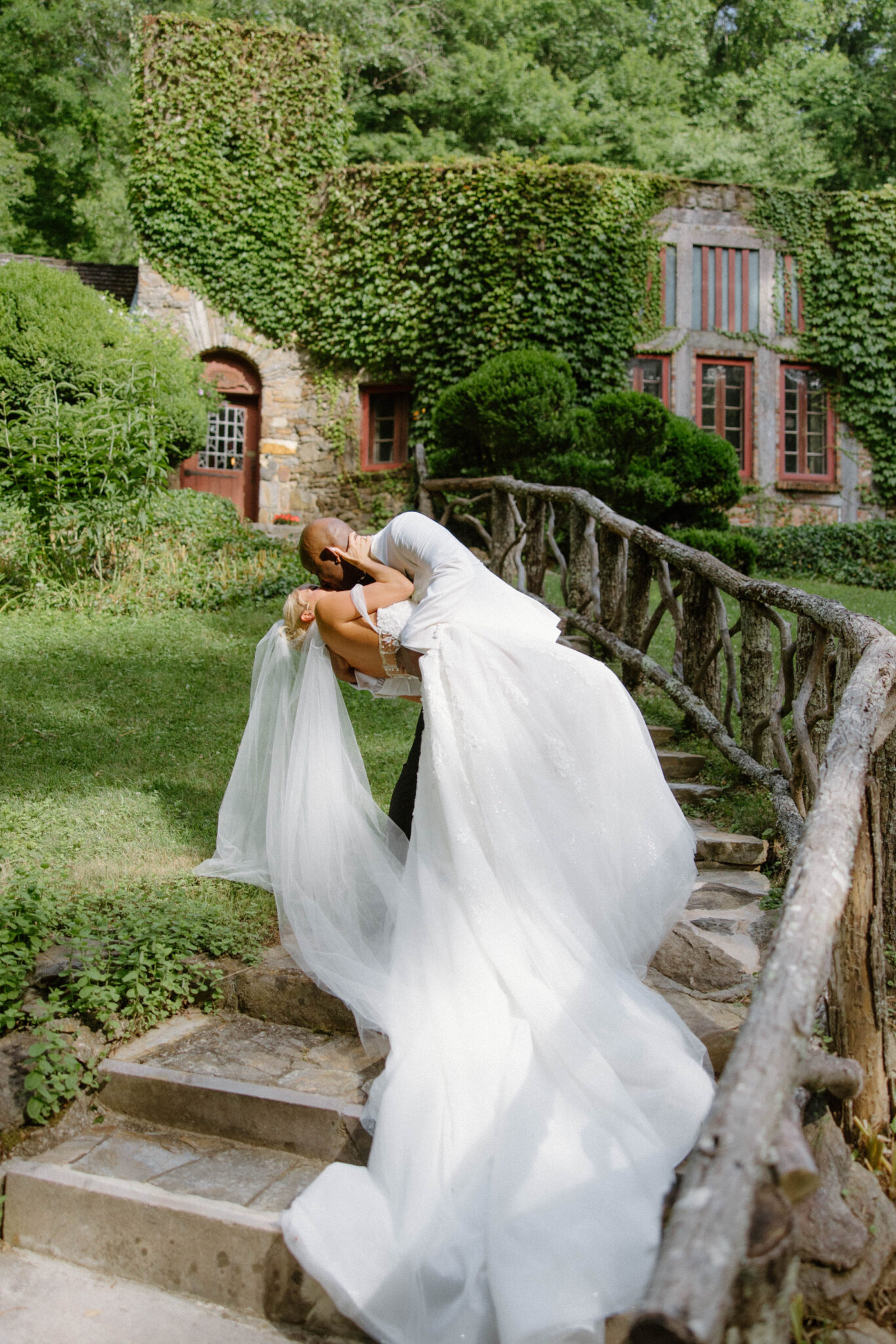 bride and groom kiss in front of Douglas Ellington House